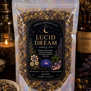 Peut inclure: Un sachet holographique de tisane Lucid Dream par Aurelia Botanica Co. L'&eacute;tiquette pr&eacute;sente un croissant de lune, un lotus bleu et des cristaux. Les ingr&eacute;dients incluent armoise, passiflore, lavande, camomille, m&eacute;lisse, souci et lotus bleu. Poids net 113 g.