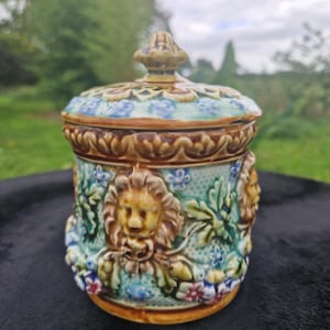 Charming covered earthenware pot, decorated with lion heads in relief surrounded by polychrome foliage and flowers, France