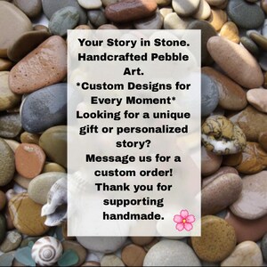 May include: A collection of smooth, multi-colored river pebbles and seashells surrounding a central white rectangular sign with black text that reads: Your Story in Stone. Handcrafted Pebble Art. Custom Designs for Every Moment. Message us for a custom order! Thank you for supporting handmade. A small pink flower icon is at the bottom.