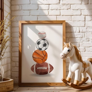 Może przedstawiać: Oprawiony wydruk przedstawiający stos piłek sportowych: baseball, piłka nożna, koszykówka i futbol amerykański. Grafika jest w drewnianej ramie. Na pierwszym planie biały koń na biegunach z brązowym siodłem.