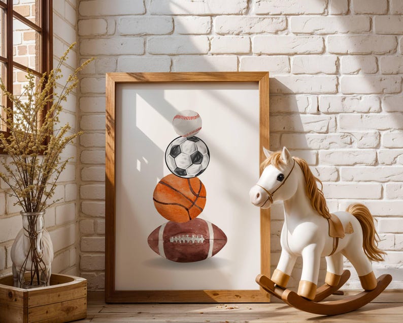Pode incluir: Uma impress&atilde;o emoldurada com uma pilha de bolas esportivas: beisebol, futebol, basquete e futebol americano. A obra de arte est&aacute; em uma moldura de madeira. Um cavalo de balan&ccedil;o branco com uma sela marrom est&aacute; em primeiro plano.