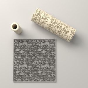 May include: A square grey silicone mat featuring a repeating embossed cat pattern, accompanied by a matching cylindrical rolling pin and a small cylindrical tool, both decorated with the same intricate cat line art design.
