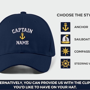 May include: Navy blue baseball cap with embroidered text "CAPTAIN NAME" and a gold anchor icon. The image also shows options for hat designs: anchor, sailboat, compass, and steering wheel. Text at the bottom says "ALTERNATIVELY, YOU CAN PROVIDE US WITH THE CLIPART YOU'D LIKE TO HAVE ON YOUR HAT."