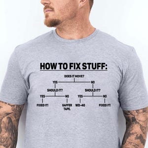 May include: A grey t-shirt with a humorous flowchart on how to fix stuff. The flowchart says "Does it move?" with "Yes" and "No" branches. The "Yes" branch says "Should it?" with "Yes" and "No" branches. The "Yes" branch says "Fixed it!" The "No" branch says "Gaffer Tape." The "No" branch of the first "Should it?" says "WD-40." The "No" branch of the second "Should it?" says "Fixed it!"