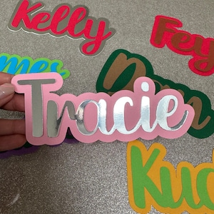 Könnte beinhalten: Eine Sammlung von bunten, maßgefertigten Namensaufklebern. Die Namen lauten "Kelly", "Fey", "Tracie" und "Kuda".