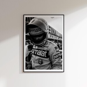 May include: Black and white framed print of a vintage Formula 1 driver in a racing suit and helmet. The helmet has the Marlboro logo, and the suit features the Parmalat and Alfa Romeo logos. The image is a portrait of the driver.