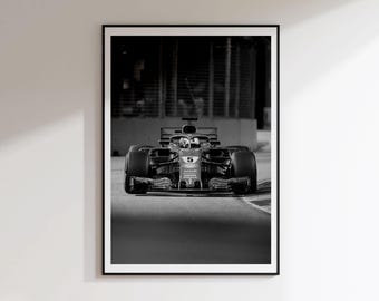 May include: A black and white framed wall art print featuring a front-facing Formula 1 race car on a track. The vehicle displays the number 5 on its nose cone, with visible tires, a cockpit, and a blurred background showing a safety fence.