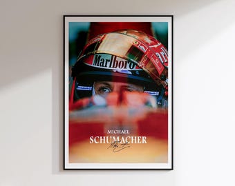 May include: A framed poster featuring a portrait of Michael Schumacher. The image shows Schumacher's face and helmet, with the "Marlboro" logo visible. The poster has a red and white color scheme, with Schumacher's name and signature at the bottom.