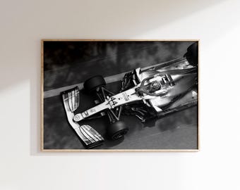 Puede incluir: Impresión enmarcada en blanco y negro de un coche de carreras de Fórmula 1, visto desde arriba. El coche plateado muestra el número 44. La imagen está sobre un fondo neutro.