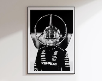 May include: A black and white framed wall art print featuring a racing driver wearing a reflective helmet and a branded team racing suit. The driver is positioned in front of a large circular Mercedes-Benz logo. The suit displays various sponsor logos.