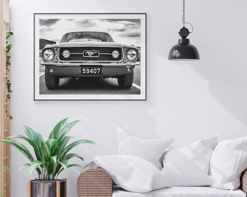 Pode incluir: Impress&atilde;o emoldurada em preto e branco de um Ford Mustang cl&aacute;ssico. A frente do carro est&aacute; centrada, mostrando a grelha, os far&oacute;is e a placa de matr&iacute;cula com o n&uacute;mero 59407. A imagem &eacute; definida contra um c&eacute;u nublado.