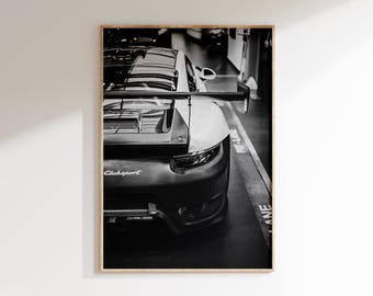 May include: Black and white framed print of a sports car's rear. The car has a spoiler and the text "ClubSport" is visible. The image is in a garage setting with a "Pit-Lane" marking on the floor.