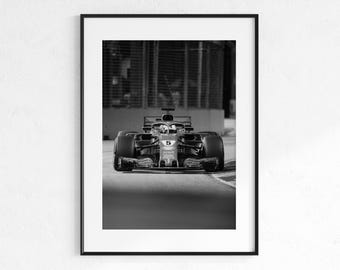 May include: Black and white framed print of a Formula 1 race car speeding down a track. The car, with the number 5, is in sharp focus, while the background is blurred. The image is a study in contrasts.