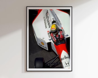 May include: A framed print of a Formula 1 race car in motion. The car is white and red with sponsor logos, including "Marlboro" and "Honda." The driver is visible in the cockpit, wearing a yellow helmet and red racing suit. The image is set against a dark background.