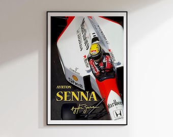 May include: A framed poster featuring a Formula 1 race car with a red and white design. The poster prominently displays the name "AYRTON SENNA" in gold lettering, along with his signature. The car has "Marlboro" and "Honda" branding.
