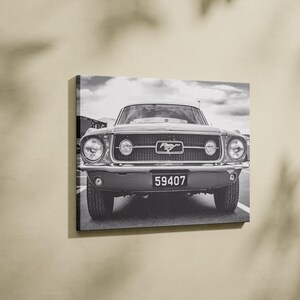 Pode incluir: Impress&atilde;o em tela a preto e branco de um Ford Mustang cl&aacute;ssico. A frente do carro est&aacute; centrada, mostrando a grelha, os far&oacute;is e a placa de matr&iacute;cula com o n&uacute;mero 59407. O log&oacute;tipo Mustang &eacute; vis&iacute;vel.