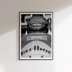 Peut inclure: Tirage encadré en noir et blanc d'un casque de course avec les logos "Honda" et "Marlboro". Les yeux du pilote sont visibles à travers la visière. L'image est un gros plan, mettant l'accent sur le casque et le visage du pilote.