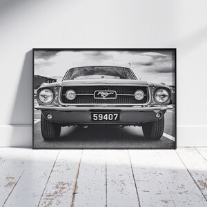 Pode incluir: Impress&atilde;o emoldurada em preto e branco de um Ford Mustang cl&aacute;ssico. O carro tem uma proeminente grelha dianteira com o emblema Mustang, far&oacute;is redondos e uma placa de matr&iacute;cula que diz "59407". A imagem &eacute; definida contra um c&eacute;u nublado.