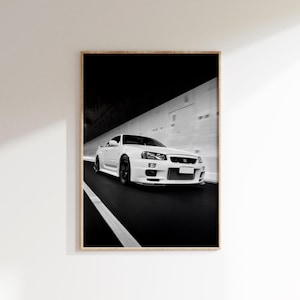 Puede incluir: Impresión enmarcada de un coche deportivo blanco a gran velocidad en una carretera. La imagen en blanco y negro destaca el diseño elegante y la velocidad del coche. El fondo está borroso, enfatizando el movimiento.