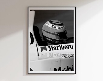 May include: Monochrome framed print of a racing helmet with the "Marlboro" logo. The helmet is yellow, red, and black. The print also shows part of a race car with the "Marlboro" logo and the word "Tencel".