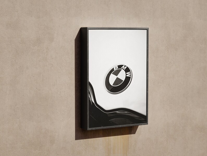 May include: Framed artwork featuring the BMW logo. The logo is a black and white circular emblem with the letters "BMW" and a propeller design. The artwork is set against a white background with a black, curved design element.