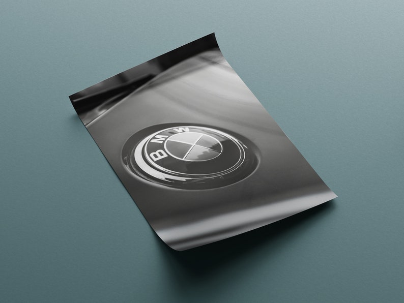 Puede incluir: Impresi&oacute;n en blanco y negro de un emblema de BMW. El emblema es circular, con el logotipo de BMW en el centro. La impresi&oacute;n est&aacute; en una hoja de papel, con una esquina ligeramente doblada.