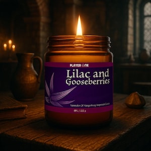 May include: A lit candle in a glass jar with a purple label that reads "Lilac and Gooseberries." The candle is on a wooden surface. The label also says "Vannefer Of Vangerberg Inspired Candle" and "60% / 222 g."