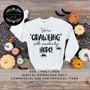 May include: White sweatshirt with the text "We're 'CRAWLING' with creativity HERE!" and spider graphics. The image is decorated with pumpkins, bats, and candy corn, suggesting a Halloween theme.