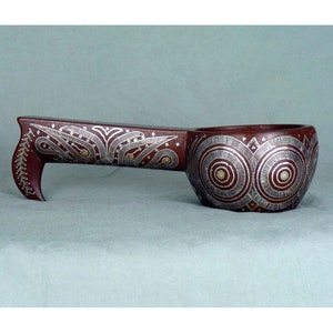 Op de afbeelding: Een houten lepel met een lange steel en een ronde kom. De steel en de kom zijn versierd met ingewikkelde zilveren en gouden patronen.