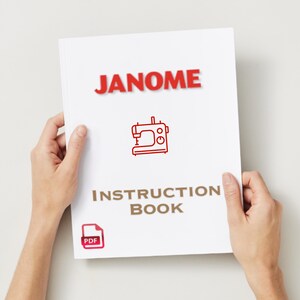 Könnte beinhalten: Ein weißes Handbuch, das von Händen gehalten wird, mit dem roten Wort "JANOME" oben. Darunter befindet sich eine rote Strichzeichnung einer Nähmaschine und die Worte "INSTRUCTION BOOK" in Braun. Ein kleines PDF-Symbol befindet sich in der unteren linken Ecke.