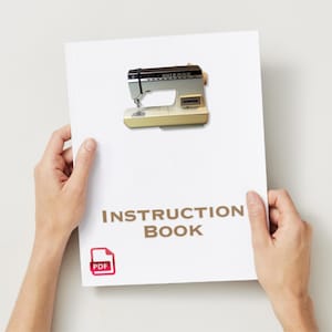 May include: A white instruction booklet for a sewing machine. The booklet has the text "INSTRUCTION BOOK" and a PDF icon. The cover of the booklet features a photo of a beige and silver sewing machine.