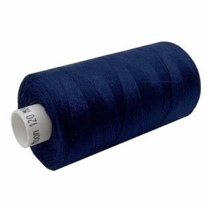 May include: A navy blue thread spool. The thread is neatly wrapped around a white cardboard core. The core label displays "120 M". The thread's sheen indicates a smooth material, suitable for sewing projects. The spool is angled.