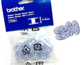 May include: A package of clear plastic bobbins for a sewing machine, with the brand name "brother" on the blue packaging. The package includes 10 bobbins, each measuring 11.5mm in diameter. Some bobbins are loose, and some are still in the plastic bag.