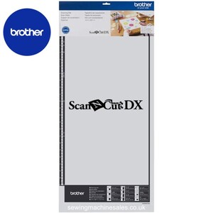 May include: A grey ScanNCut DX cutting mat with a black ScanNCut DX logo and a black ruler on the left side. The mat is packaged in a clear plastic sleeve with a white label that says "ScanNCut DX" and "Brother at your side".