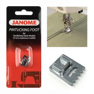 May include: A Janome pintucking foot for oscillating hook models, with a 5 mm maximum width, is displayed in a package and in use on a sewing machine. The package is black and red, and the foot is silver.