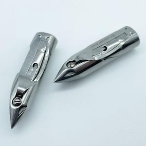 May include: Two silver sewing machine needles with a pointed tip and a metal casing. The needles are designed for use with a sewing machine.