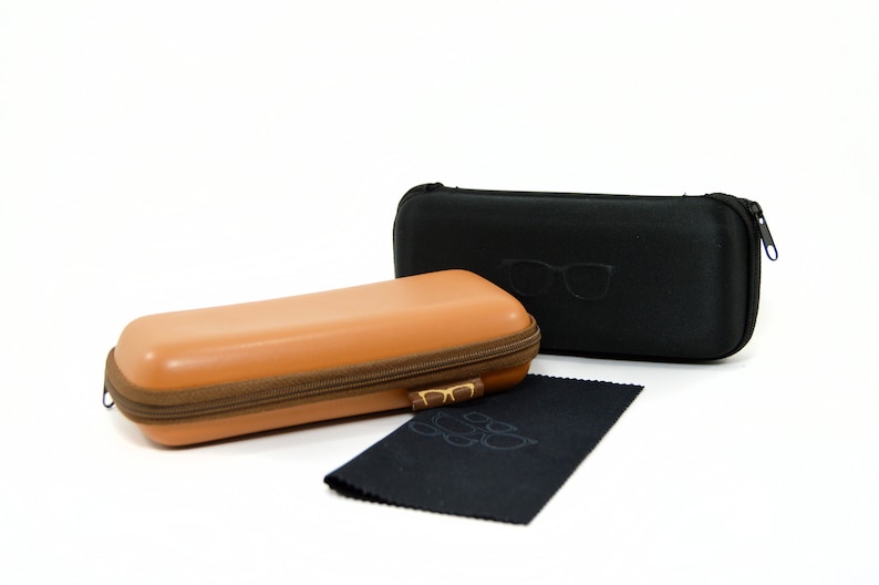 May include: Two zippered cases for glasses, one brown and one black. The black case has a pair of glasses embossed on the front. A black microfiber cleaning cloth is also included.