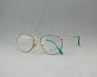 May include: Gold-tone metal eyeglasses with green frames and clear lenses. The brand name "Benetton" is printed on the right lens.