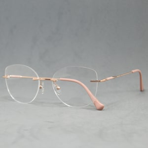 Lunettes de vue Métal sans monture Disponible pour achat. Femme classique élégante. Oeil de chat en forme de papillon Taille régulière. Rose pâle crème doré