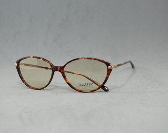 May include: Tortoise shell eyeglasses with gold accents and brown lenses. The brand name "KAFFER" is printed on the right lens.