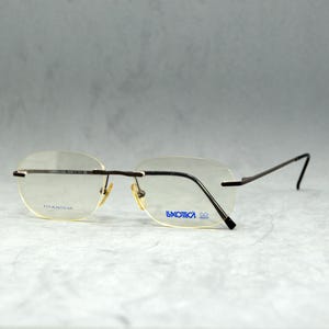 Lunettes de vue vintage sans monture en titane de la collection LUXOTTICA, non portées. Carré arrondi unisexe. Homme Femme. Lunettes Rx 100 % TITANE pur