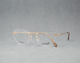Gafas sin montura de alta gama. Montura de titanio puro con identificación. Nuevas gafas premium seleccionadas. Gafas para mujer. Mariposa. Doradas, marrón claro. Moda clásica.