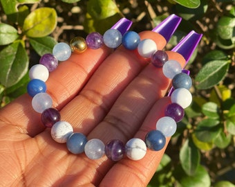 May include: A beaded bracelet with amethyst, blue agate, white howlite, and a gold bead charm.