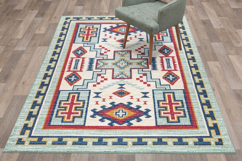May include: A Southwestern-style rug with a geometric pattern in shades of blue, red, yellow, and white. The rug has a light blue background with a border of yellow and blue.