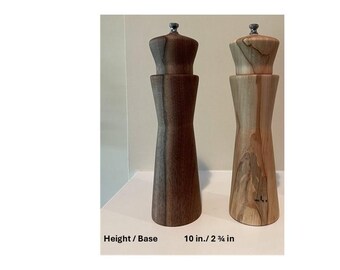 Op de afbeelding: Twee houten pepermolens, één donkerbruin en één lichtbruin, staan naast elkaar. De donkerbruine molen is 25,4 cm hoog met een basis van 6 cm. De lichtbruine molen heeft een natuurlijke houtnerf. Beide hebben een zilverkleurige bovenkant.