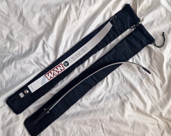 Puede incluir: Un arco de tiro con arco negro con una etiqueta blanca y roja que dice "W&W WIN&WIN" está en una funda de tela negra.
