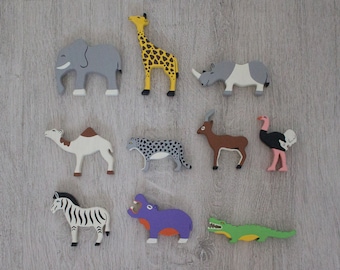 May include: A set of ten wooden animal figurines, including a giraffe, elephant, rhinoceros, camel, leopard, antelope, ostrich, zebra, hippopotamus, and crocodile. The figurines are painted in various colors, including brown, gray, yellow, black, white, and green.