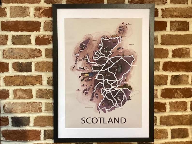 May include: A framed print of a map of Scotland with a watercolor-style background. The map shows major cities and landmarks, with the word "SCOTLAND" printed at the bottom.