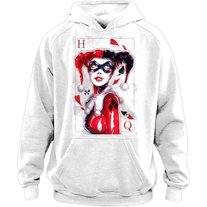May include: White hooded sweatshirt featuring a graphic of a playing card with a Harley Quinn illustration. The card shows the Queen of Hearts with red, black, and white details. The hoodie has a front pocket and a drawstring hood.