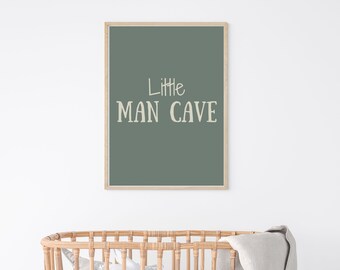 May include: A framed print with a green background and the text "Little Man Cave" in a cream color.